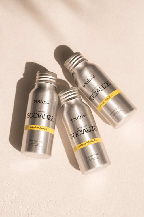 Three SoulMe Socialize Ritual Shot bottles in mango ginger on warm linen