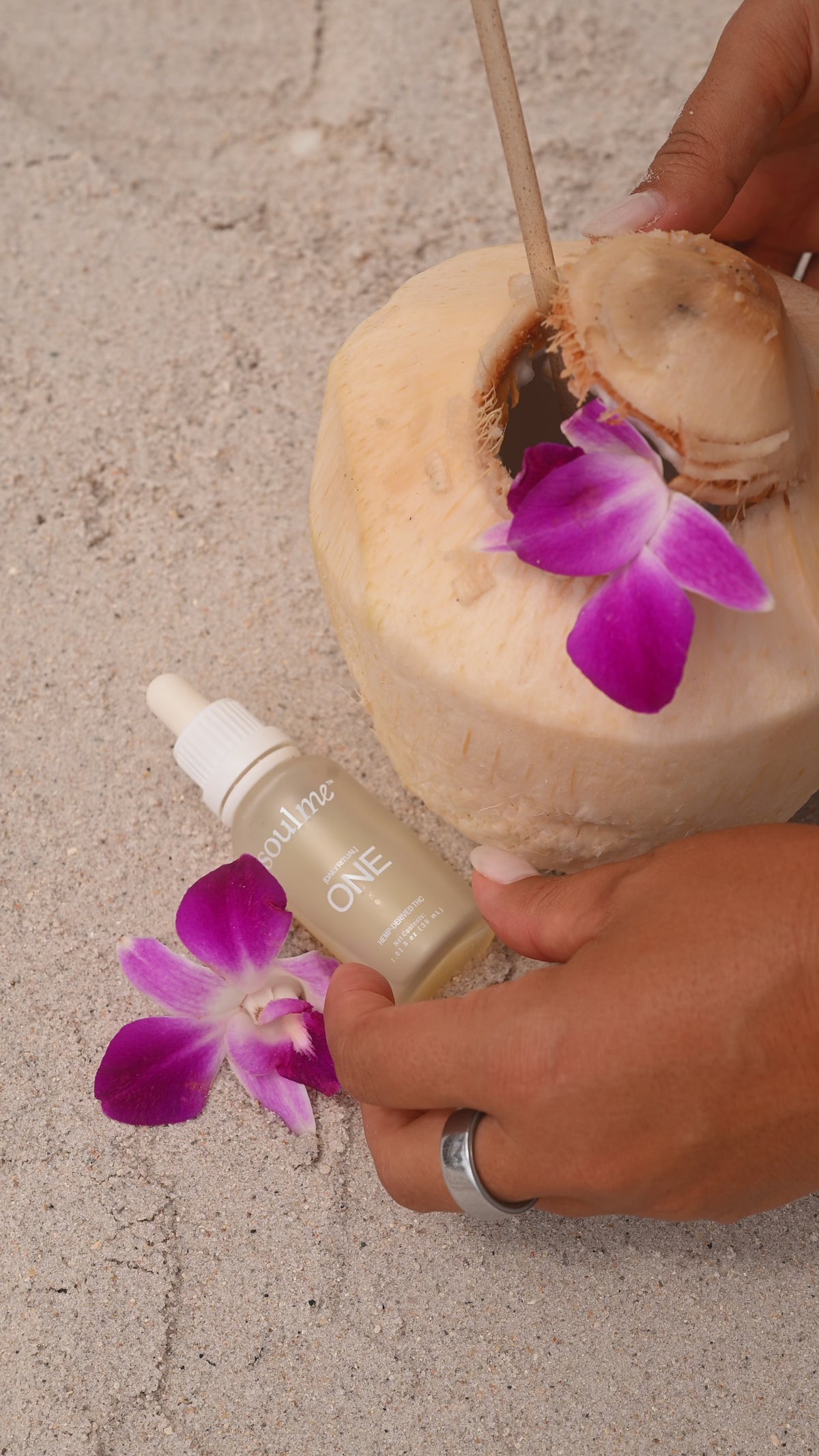 Adding SoulMe ONE to a fresh coconut on the beach